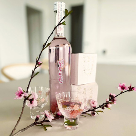 Bottle of cherry blossom liqueur with two tasting glasses